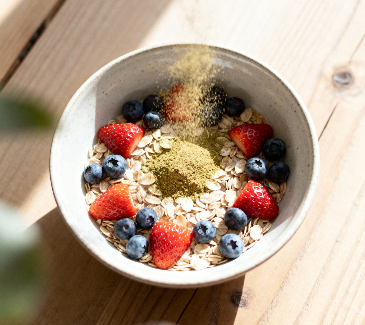 Bowl of oats with strawberries and blueberries on a wooden surface